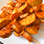 Kamote Que, also known as camote cue or sweet potato fritters, is a popular snack in the Philippines. It is made by deep-frying slices of sweet potatoes coated in brown sugar and skewered on bamboo sticks.