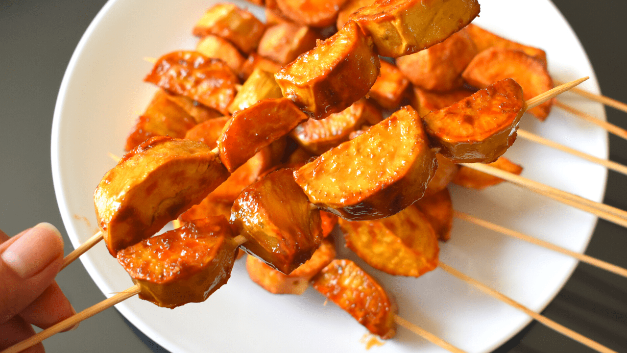 Kamote Que, also known as camote cue or sweet potato fritters, is a popular snack in the Philippines. It is made by deep-frying slices of sweet potatoes coated in brown sugar and skewered on bamboo sticks.