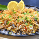 Bangus Sisig is a Filipino dish made from milkfish (bangus) that has been deboned, flaked, and cooked with various ingredients such as onions, garlic, chili peppers, and mayonnaise. It is typically served on a sizzling plate and topped with a raw egg for added creaminess.