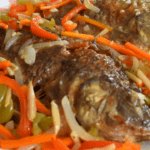 Escabeche is a popular Filipino dish that consists of fried fish or meat, topped with a sweet and sour sauce made from vinegar, soy sauce, sugar, and various spices. This dish has Spanish origins and the name "escabeche" comes from the Spanish word "escabechar", which means to marinate in an acidic solution.