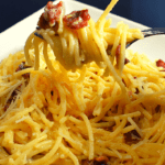 Spaghetti Carbonara is an Italian pasta dish made with spaghetti, eggs, Parmesan cheese, pancetta or bacon, and black pepper. The traditional recipe does not include cream but some variations may add it.
