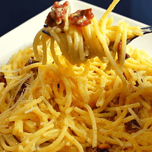 Spaghetti Carbonara is an Italian pasta dish made with spaghetti, eggs, Parmesan cheese, pancetta or bacon, and black pepper. The traditional recipe does not include cream but some variations may add it.