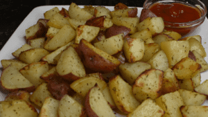 Roasted potatoes are a dish made by cooking potatoes in an oven or on a stovetop until they develop a crispy, golden-brown exterior. The potatoes are usually cut into small pieces and tossed with oil, herbs, and spices before being cooked to enhance their flavor.