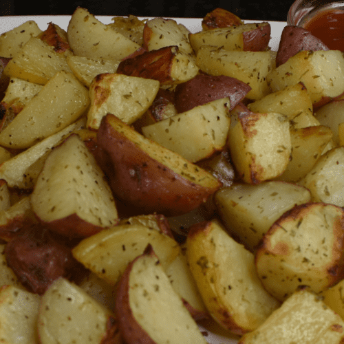 Roasted potatoes are a dish made by cooking potatoes in an oven or on a stovetop until they develop a crispy, golden-brown exterior. The potatoes are usually cut into small pieces and tossed with oil, herbs, and spices before being cooked to enhance their flavor.