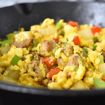 A delicious meal made with diced potatoes, sausage, eggs, green onion, cheddar cheese, green and red pepper.