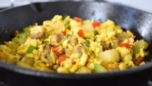 A delicious meal made with diced potatoes, sausage, eggs, green onion, cheddar cheese, green and red pepper.