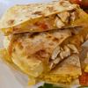 Chicken quesadilla is a mouth-watering Mexican dish. It consists of a tortilla filled with cooked chicken, melted cheese, and other delicious ingredients, then folded in half and toasted on a skillet until golden brown.