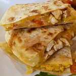 Chicken quesadilla is a mouth-watering Mexican dish. It consists of a tortilla filled with cooked chicken, melted cheese, and other delicious ingredients, then folded in half and toasted on a skillet until golden brown.