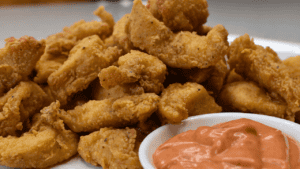 Popcorn chicken is a popular snack that originated in the United States. It consists of bite-sized pieces of chicken, typically coated in batter or breadcrumbs and then deep-fried until crispy.