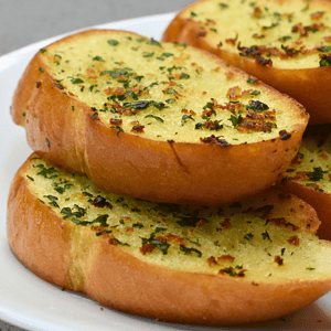 Garlic bread is a popular side dish made from sliced bread, typically baguette or Italian loaf, that has been seasoned with garlic and butter before being baked or grilled. It is a staple in Italian cuisine but has now become a beloved addition to meals all over the world.